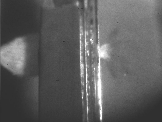 The characteristic “splash” pattern resulting from the perforation of a glass target array consisting of four 3-mm thick float glass plates, with 2.5-mm spacing between each plate.