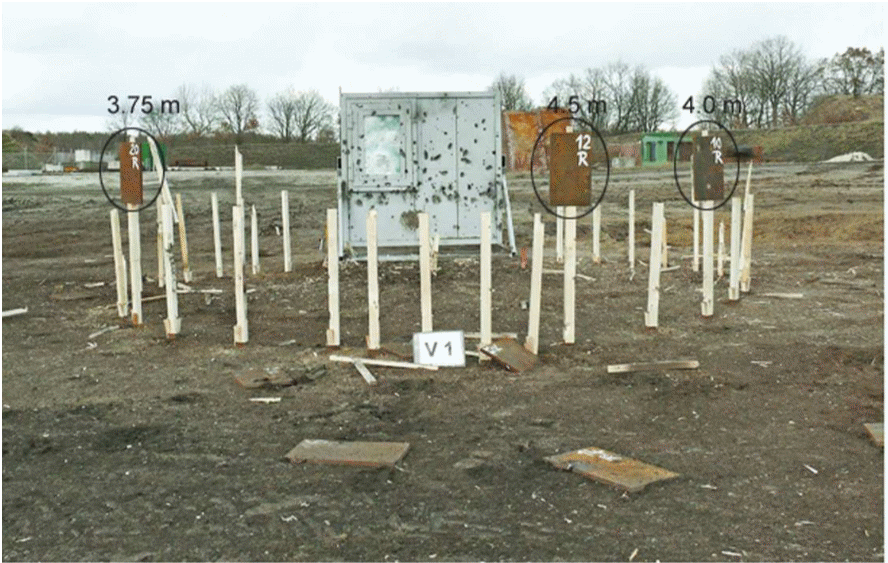 Test arena after detonation of the 155 mm high explosive projectile DM 21. Surprisingly, three momentum plates remain standing on their fixtures.